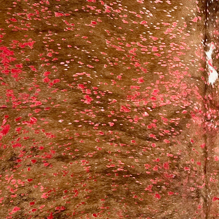 Closeup of this Tricolor Colombian Cowhide, showing brown with black, brindle markings, and a red, metallic acid wash (COAW515)