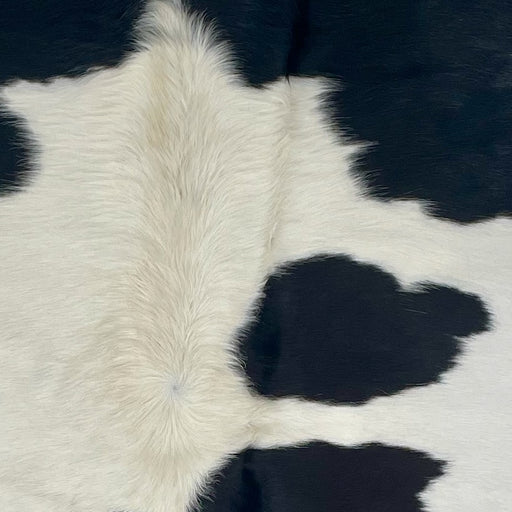 Closeup of this Brazilian Cowhide, showing white with large and small, black spots that have hints of brown (BRBKW260)