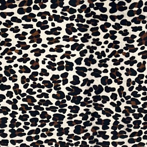 Closeup of this Brazilian Cowhide, showing off-white with a black and brown, stenciled, leopard print (BRLP150)