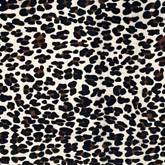 Closeup of this Brazilian Cowhide, showing off-white with a black and brown, stenciled, leopard print (BRLP150)