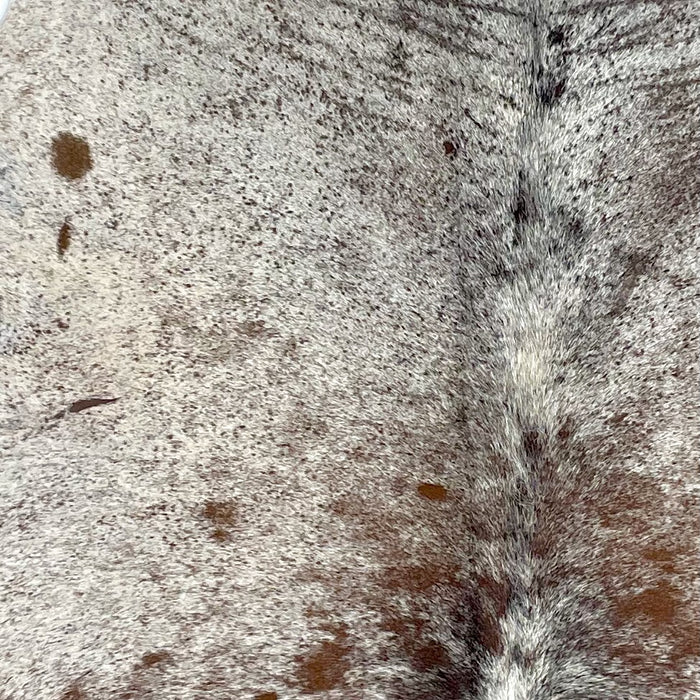 Closeup of this Tricolor, Speckled, Brazilian Cowhide, showing white with brown and black speckles, and a few brown spots (BRSP2559)