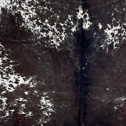 Closeup of this Large Blackish Speckled Brazilian Cowhide, showing white with blackish brown speckles and spots, and mostly solid blackish brown down the middle  (BRSP3309)