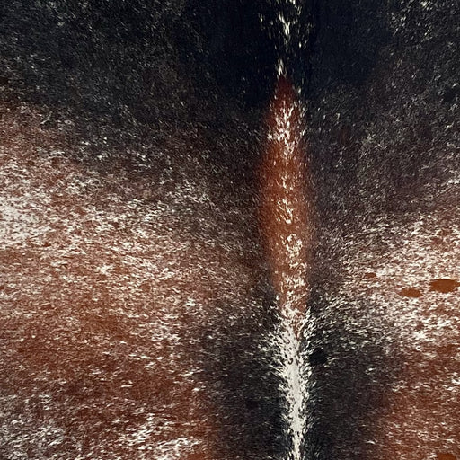 closeup of this Large Tricolor Speckled Brazilian Cowhide, showing off-white with reddish brown and black spots and speckles (BRSP3599)
