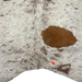 Closeup of this Ivory and Brown Speckled Brazilian Cowhide, showing one brand mark on the right side of the butt  (BRSP3629)