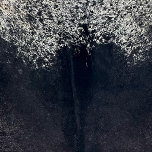 Closeup of this Speckled Brazilian Cowhide, showing mostly solid black on the back, and white with black speckles and spots on the shoulder (BRSP3721)