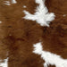 Closeup of this Brown and White Calfskin, showing white with large and small, brown spots (CALF620)