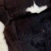 Closeup of this Calfskin, showing blackish brown with a small, white spot in the middle of the shoulder, and white on the belly (CALF686)