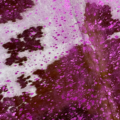 Closeup of this Colombian cowhide, showing, white with brown spots, and a metallic, fuchsia acid wash (COAW414)