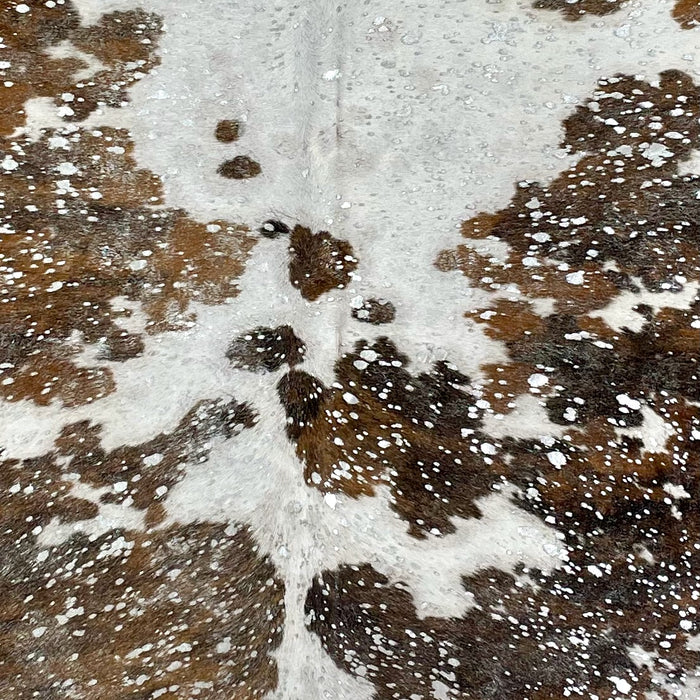 Closeup of this Tricolor, Colombian Cowhide, showing white with brown and black spots, and a silver, metallic acid wash (COAW446)