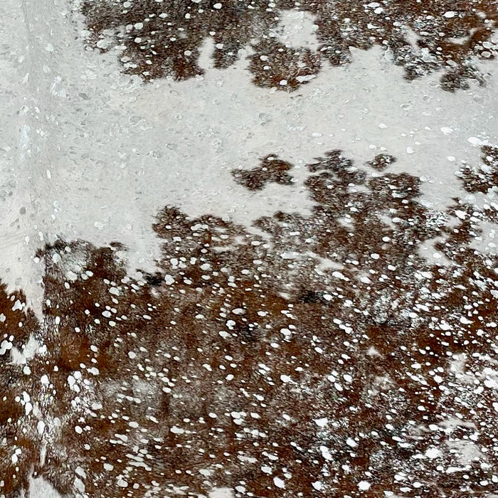 Closeup of this Tricolor, Colombian Cowhide, showing white with brown and black spots, and  a silver, metallic acid wash (COAW447)