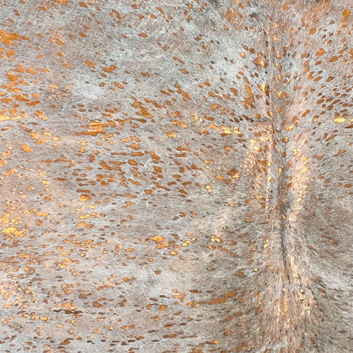 Closeup of this Colombian Cowhide, showing off-white and light brown, with an Orange, metallic Acid Wash (COAW470)