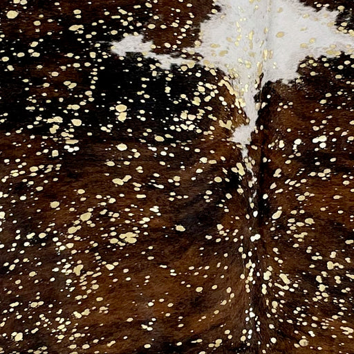 Closeup of this Colombian Tricolor Cowhide, showing brown, black, and white, with a metallic, Gold Acid Wash  (COAW502)