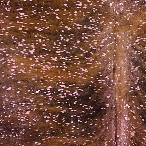 Closeup of this XL Colombian Brindle Cowhide, showing a brown and black, brindle patter, and a metallic, Pink Acid Wash (COAW508)
