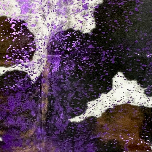 Closeup of this Large Colombian Tricolor Cowhide, showing black with large, brown and white spots, and a metallic, purple acid wash (COAW512)