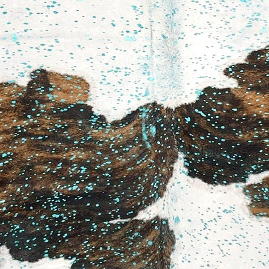 Large Tricolor Colombian Cowhide, showing white with large spots that have a brown and black, brindle pattern, and a metallic, turquoise acid wash (COAW519)