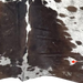 Closeup of this Chocolate and White Speckled Colombian Cowhide, showing  one brand mark on the right side of the butt  (COSP3552)