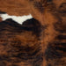 Closeup of this Colombian, Tricolor Cowhide, showing a red brown and black, brindle pattern, with a white spot on the left side of the shoulder (COTR1020)