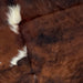 Closeup of this Colombian Tricolor Cowhide, showing a mix of dark reddish brown and black and two of three white spots down the spine (COTR1034)