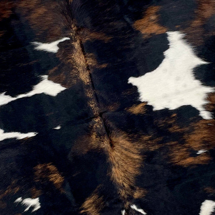 Closeup of this Colombian Tricolor Cowhide, showing white with large and small spots that have a mix of black and brown (COTR1058)