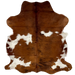 Colombian Tricolor Cowhide:  mostly brown, with a few white spots, some having brown speckles, and it has black, brindle markings down the middle of the lower half of the hide, and it has longer hair on the belly - 5'10" x 4'8" (COTR1077)