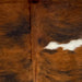 Closeup of this Large Colombian Tricolor Cowhide, showing a reddish brown and black, brindle pattern, with one white spot on the right side of the back (COTR1168)