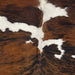 Closeup of this Colombian, Tricolor Cowhide, showing large spots with a reddish brown and black, brindle pattern, with a large, white spot in the middle (COTR1183)