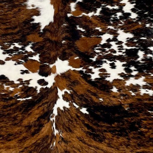 Closeup of this Colombian Tricolor Cowhide, showing white with large spots that have a brown and black, brindle pattern, and small, black and brown spots (COTR1193)