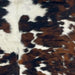 Closeup of this Colombian Tricolor Cowhide, showing white with large and small spots that have a mix of black and brown (COTR1220)