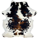 Colombian Tricolor Cowhide: white with large and small spots that have a mix of black and brown, and it has long hair down part of the spine - 7' x 5'5" (COTR1325)