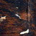 Closeup of this Colombian Dark Tricolor Cowhide, showing a black and reddish brown, brindle pattern, with a few small white on the back (COTR1385)