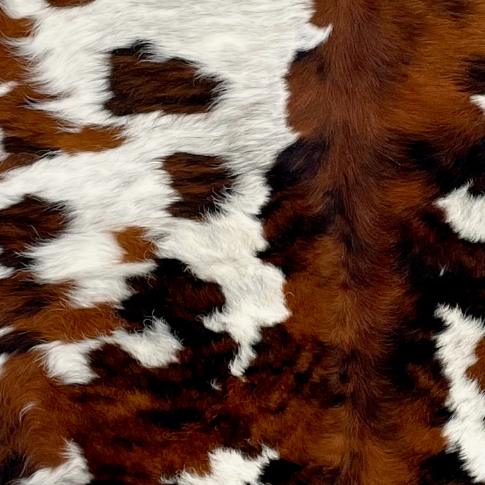 Closeup of this Colombian Tricolor Cowhide, showing white with black speckles, and large and small spots that have a mix of red brown and black  (COTR1462)
