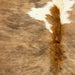 Closeup of this Colombian Tricolor Cowhide, showing light brown with faint, black, brindle markings, and one white spot down the middle (COTR1471)
