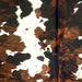 Closeup of this Large Tricolor Speckled Colombian Cowhide, showing white with brown and black speckles, and large and small spots that have a mix of black and reddish brown - 7'9" x 6' (COTR1479)
