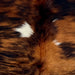 Closeup of this Colombian Tricolor Cowhide, showing a red brown, golden brown, and black, brindle pattern, with a couple small, white spots (COTR1541)