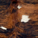 Closeup of this Colombian Tricolor Cowhide, showing large spots with a  black and reddish brown, brindle pattern and three small, white spots (COTR1556)
