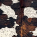 Closeup of this Colombian Cloudy Speckled Tricolor Cowhide, showing white with cloudy, black speckles, and large and small spots that have a black and brown, brindle pattern (COTR1559)