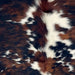 Closeup of this Colombian Tricolor Cowhide, showing a mix of reddish brown and black with white spots, and longer hair down the spine (COTR1636)