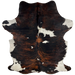 Colombian Tricolor Cowhide:  has a black and reddish brown, brindle pattern, with a few white spots in the middle, one having black speckles in it, and white with black speckles and spots on the belly and shanks - 7'1" x 4'11" (COTR922)
