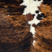 Closeup of this XL, Colombian, Tricolor Cowhide, showing a brown and black, brindle pattern, and white spots down the spine (COTR927) 