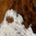 Closeup of this Tricolor Mini Cowhide:, showing a mix of brown and black, and white with black speckles and brown and black spots along the lower edge (MINI256)