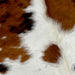 Closeup of this XS, Tricolor Cowhide, showing white with spots that have a mix of reddish brown and black (XS223)