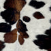 Closeup of this XS Tricolor Cowhide, showing off-white with black speckles, and spots that have a mix of black and brown (XS393)