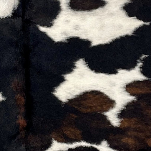 Closeup of this XS Dark Tricolor Cowhide, showing black, with some brown mixed in, and white spots that have black speckles (XS510)