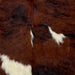 Closeup of this XS Tricolor Cowhide, showing a dark brown and black, brindle pattern, and some small and large, white spots (XS535)