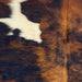 Closeup of this XS Tricolor Cowhide, showing a mix of black and reddish brown, and a few small and large, off-white spots  (XS606)