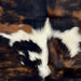 closeup of this XS Tricolor Cowhide, showing a brown and black, brindle pattern, and white spots across the middle   (XS626)