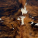 Closeup of this XS Tricolor Cowhide, showing a brown and black, brindle pattern with small white spots  (XS646)