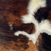 Closeup of this XS Tricolor Cowhide, showing a reddish brown and black, brindle pattern and white and off-white spots down the middle (XS660)