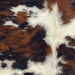 Closeup of this XS Tricolor Cowhide, showing a black and brown, brindle pattern and small, white spots  (XS676)
