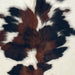 Closeup of this XS Tricolor Cowhide, showing white with large and small, black and brown spots (XS677)